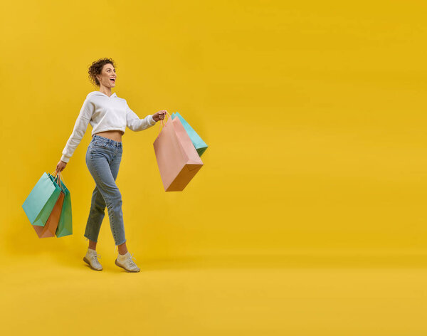 Delighted Female Shopper Paper Bags Walking Alone Shopping Studio Side Royalty Free Stock Images