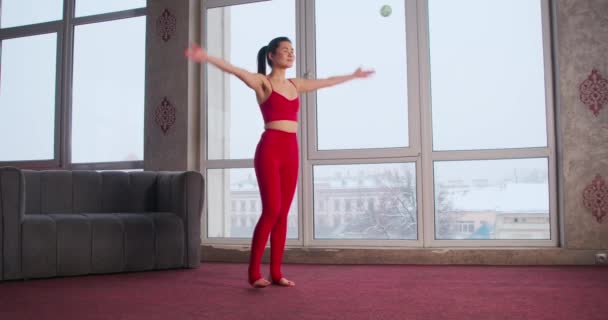 裸足の少女のサイドビュー レッドカーペットの上に立って 手を上げ ストレッチ赤いスポーツスーツを着ていた きれいな ポニーテールヨガを練習しているブルネットの女性 ヨガの概念 — ストック動画