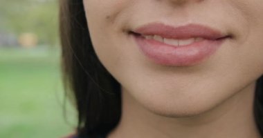 Uzun, esmer, ayakta duran, gülümseyen, beyaz dişli kameraya bakan güzel bir kız. Kızım, açık havada parkta mezun ol. Kadın güzelliği kavramı.