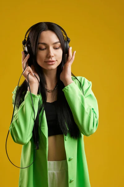 Chica Consciente Tocando Cuidadosamente Los Auriculares Mientras Escucha Canción Interior — Foto de Stock