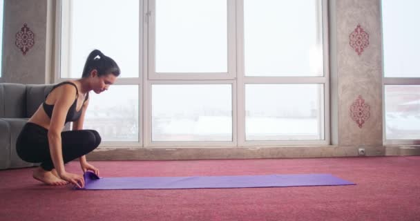Esmer Kuyruklu Genç Bir Bayanın Dairede Menekşe Yoga Minderi Yuvarlarken — Stok video