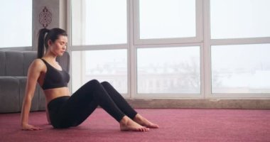 Güzel, at kuyruklu esmer bir kız yoga yapıyor, poz veriyor, meditasyon yapıyor, esniyor. Güzel, genç bir bayan spor takım elbise giyiyor. Modern gerçeklik kavramı.