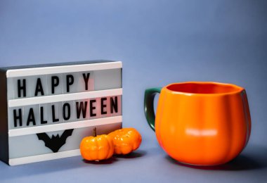 Beyaz masada turuncu ve siyah mumlu Cadılar Bayramı balkabakları.