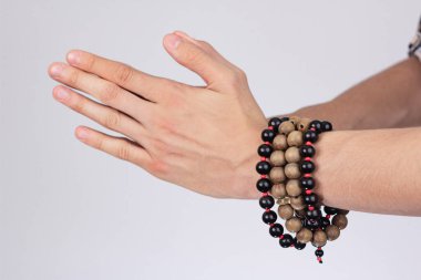 Çıplak elleriyle güçlü bir erkek tokalaşması ve Budist tespihi fasulyesi.