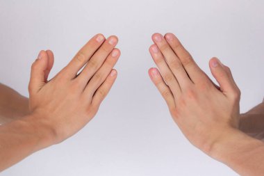 Erkeklerin elleri beyaz arka planda birbirini selamlıyor.