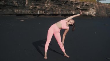 Deniz kıyısında sabah egzersizi yapan genç bir kadının ön görüntüsü..