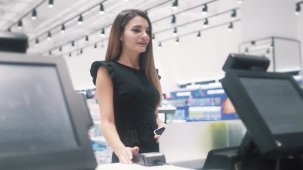 Молодая женщина имеет небольшой разговор с продавцом во время оплаты в магазине косметики. — стоковое видео