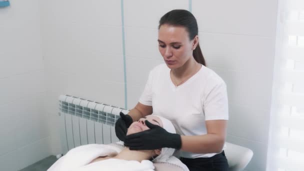 Massage de la peau en clinique de cosmétologie pour jeune belle femme. — Video