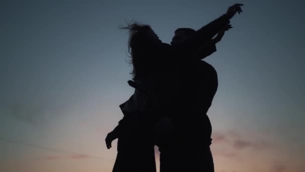 Ralenti des silhouettes sombres homme rencontre sa petite amie et câlin. — Video