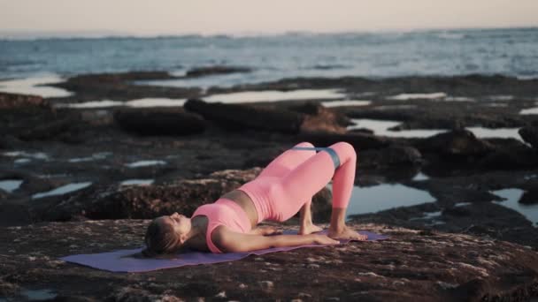 Mulheres desportivas exercitam-se no litoral. Treinamento de fitness no tapete de ioga. — Vídeo de Stock