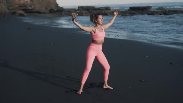 Vue latérale de belle jeune femme faisant squats au bord de la mer. — Video