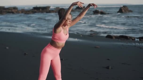 Primer plano de la joven haciendo ejercicios de abdominales en la orilla del mar. — Vídeos de Stock