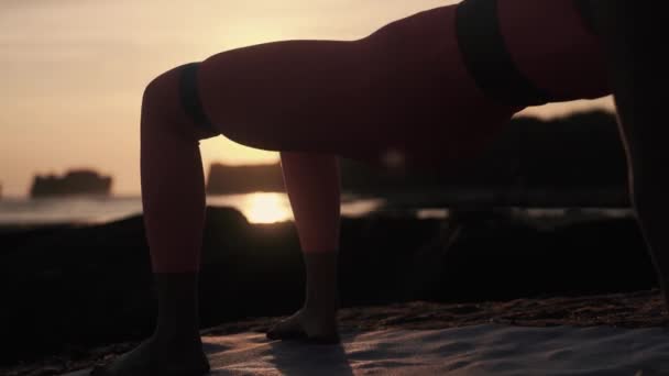 Mulheres desportivas exercitam-se no litoral. Treinamento de fitness no tapete de ioga. — Vídeo de Stock