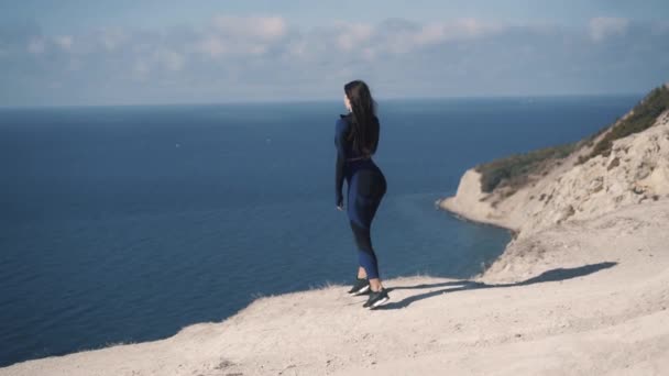Bonito jovem caucasiano menina atleta e desabotoando um casaco de pé no litoral — Vídeo de Stock