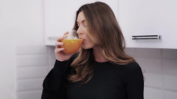 Långhårig Mörkblond Med Ett Glas Apelsinjuice Glada Kvinna Tar Klunk — Stockvideo