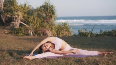 Esnek ve formda bir kadın huzur içinde yoga yapıyor. Atletik kız bacak ve vücut bükümleriyle esneme egzersizi yapıyor. Zindelik ve yogayla formda kalmak. 