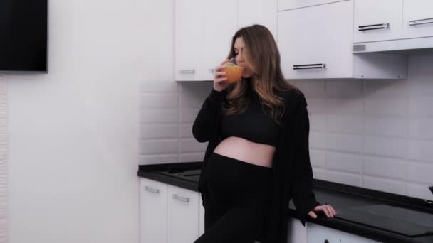 Young Pregnant Woman Black Clothes Enjoying Fresh Orange Juice Kitchen — Stock Video