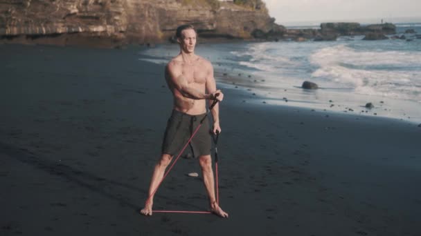 Vorderansicht Des Perfekten Körpersportlers Trainiert Arme Mit Gummiband Junger Mann — Stockvideo