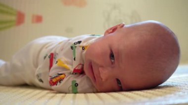 Bir bebek oyun hasırında kafasını karnının üstünde tutmayı öğrenir..