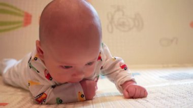 Bir bebek oyun hasırında kafasını karnının üstünde tutmayı öğrenir..