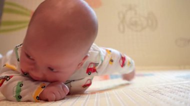 Bir bebek oyun hasırında kafasını karnının üstünde tutmayı öğrenir..