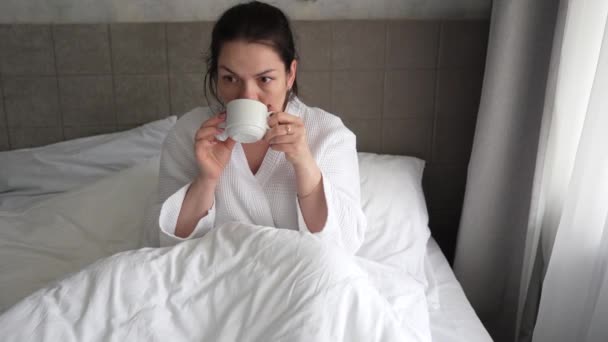 Młoda Kobieta Rano Leży Łóżku Pije Kawę Oglądając Wiadomości Przez — Wideo stockowe