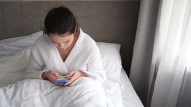 Sabahları genç bir kadın yatakta uzanıyor ve kahve içiyor. Telefondaki mesajlara bakıyor. Kadın uyanır ve evinde bir bardak sıcak içecekle akıllı telefonuna bakar..