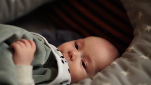 Niño jugando en una cama en casa. Bebé está jugando acostado en la cama — Vídeos de Stock