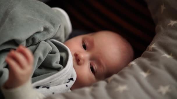 Bebek evde bir yatakta oynuyor. Bebek yatakta yatıyor. — Stok video