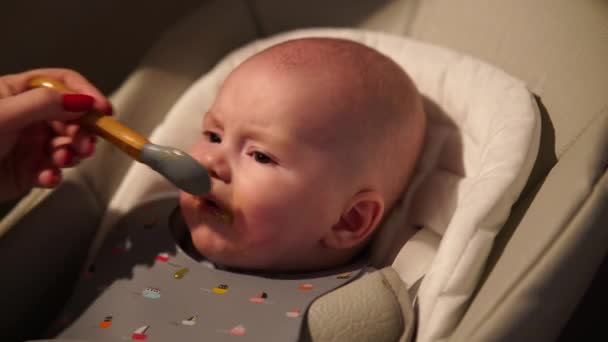 Moeder Geeft Eten Aan Baby Jongen Puree Van Lepel Kinderstoel — Stockvideo