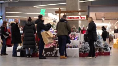 Moskova, Rusya - 26 Aralık 2021: İnsanlar yeni yıl için dekore edilmiş bir alışveriş merkezinden hediye alıyorlar