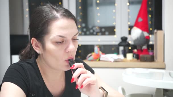 Vaping girl smoking an electronic cigarette indoors decorated for christmas. Life-threatening bad habit. — Stock Video