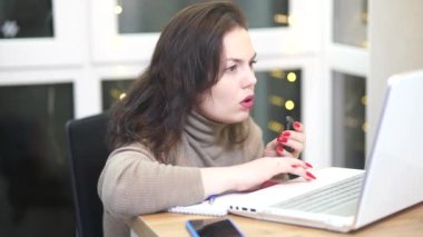 Workplace of freelance worker at home office. Young woman works using computer and other devices. Remote job concept.