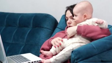 Serbest çalışan anne tecrit sırasında evdeki ofiste koltukta oturuyor. Evde bir çocukla uzaktan çalışma.