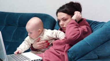 Serbest çalışan anne tecrit sırasında evdeki ofiste koltukta oturuyor. Evde bir çocukla uzaktan çalışma.