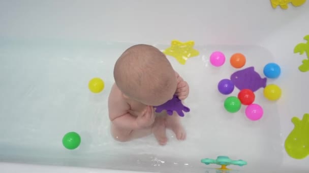 Милый Маленький Мальчик Принимает Ванну Игрушками Белой Ванной — стоковое видео