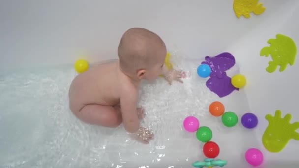 可爱的小男孩带着玩具在白色的浴室里洗澡 — 图库视频影像