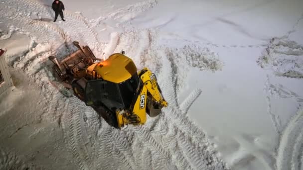 俄罗斯莫斯科 2022年2月10日 拖拉机与刮胡刀桶从路上带走了成堆的雪 在城市环境中推土机用铲子铲雪 — 图库视频影像