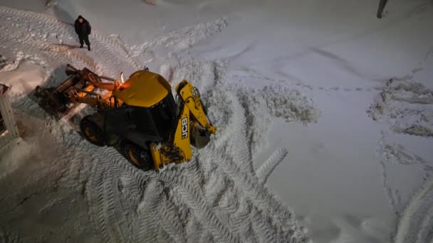 俄罗斯莫斯科 2022年2月10日 拖拉机与刮胡刀桶从路上带走了成堆的雪 在城市环境中推土机用铲子铲雪 — 图库视频影像