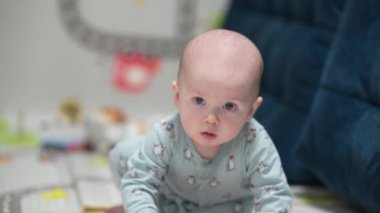 Evde oyuncaklarla oynayan sürünen komik bir bebek. Bebek evde oyuncaklarla oynuyor..