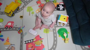 Mutlu küçük bebek oynuyor ve odada sürünüyor
