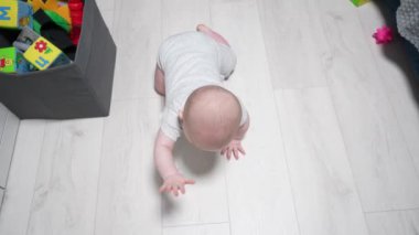 Mutlu küçük bebek oynuyor ve odada sürünüyor