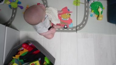 Mutlu küçük bebek oynuyor ve odada sürünüyor