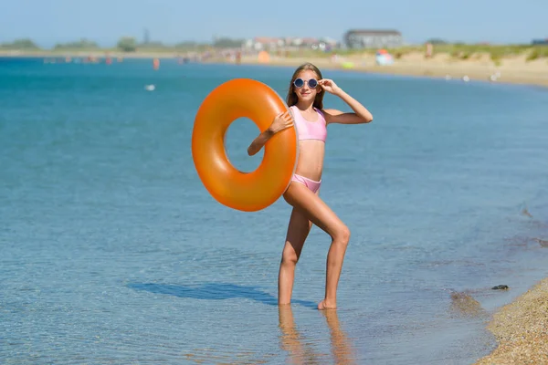 Ein Teenager Mädchen Einem Rosafarbenen Badeanzug Mit Orangefarbenem Gummiring Steht — Stockfoto