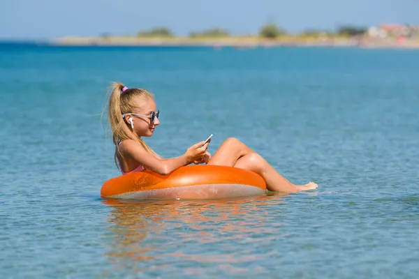 Gadis Remaja Berenang Laut Pada Lingkaran Dengan Telepon — Stok Foto