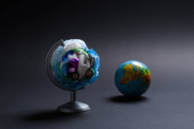 Gezegen çöp kirliliği konsepti. Küre, yalan söyleyen gezegenin arka planındaki enkazdan oluşmuş karanlık bir arka planda. Enkaz küresi üzerine seçici odaklanma