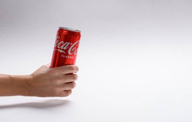 Vladimir, Rusya - Kasım 2021: Hafif arka planda bir kadın elinde bir kutu Coca-Cola. Sağda boş bir alan var..