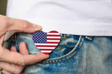 Amerika 'nın vatanseveri! Tahta rozet ve Amerikan bayrağı bir adamın elinde kalp şeklinde..