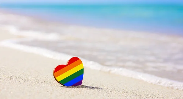 LGBT kalbi kumlu sahilde denizin arka planında. lgbt çiftleri için en iyi tatil yeri kavramı