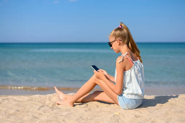 Ragazza Seduta Sulla Spiaggia Con Uno Smartphone Sullo Sfondo Del — Foto Stock